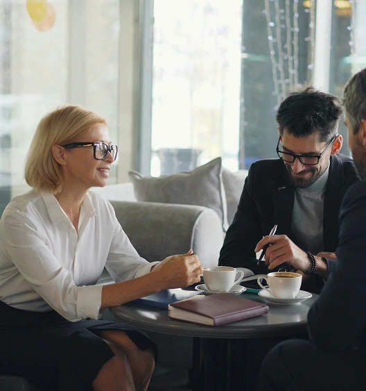 Business consultants in a strategic advisory meeting over coffee — Protea Consulting