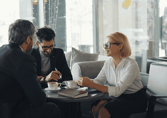 Business consultants in a strategic advisory meeting over coffee — Protea Consulting